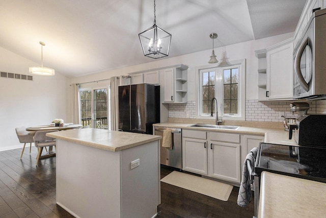 1200 Schuring Rd, Portage, MI 49024 - kitchen featuring open shelves, stainless steel appliances, vaulted ceiling, a sink, and a center island