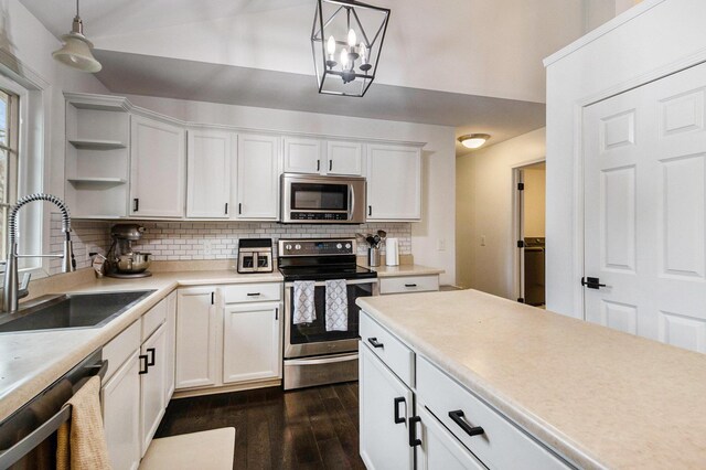 1200 Schuring Rd, Portage, MI 49024 - kitchen featuring stainless steel appliances, a sink, open shelves, dark wood-style flooring, and decorative backsplash
