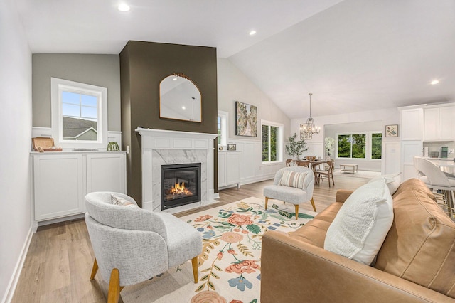 LOT166 Wren Ct, Caledonia, MI 49316 - living area featuring a chandelier, light wood finished floors, a premium fireplace, healthy amount of natural light, and high vaulted ceiling