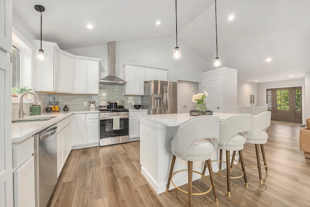 LOT166 Wren Ct, Caledonia, MI 49316 - kitchen with stainless steel appliances, wall chimney exhaust hood, a sink, a kitchen island, and light wood finished floors