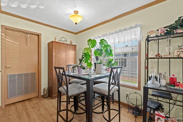 11091 Aspen Ct, South Lyon, MI 48178 - dining area with light wood-style floors, a textured ceiling, crown molding, and baseboards