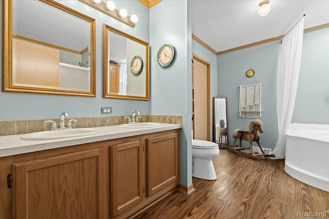 11091 Aspen Ct, South Lyon, MI 48178 - bathroom with ornamental molding, double vanity, toilet, a bathtub, and wood finished floors
