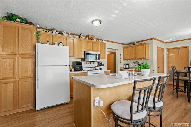 11091 Aspen Ct, South Lyon, MI 48178 - kitchen featuring white appliances, a sink, a textured ceiling, light wood-style floors, and ornamental molding
