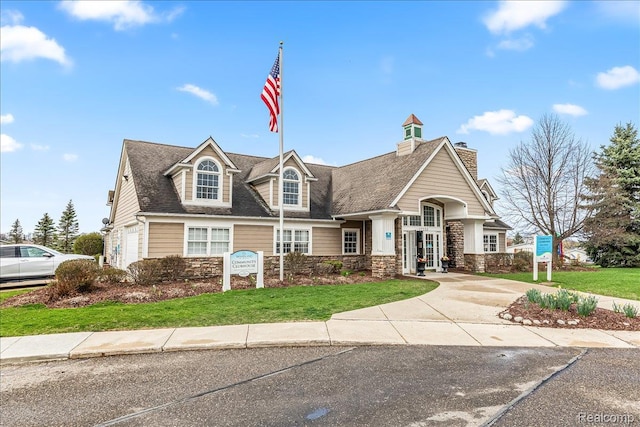 11091 Aspen Ct, South Lyon, MI 48178 - view of front of house featuring stone siding, a front yard, and a chimney