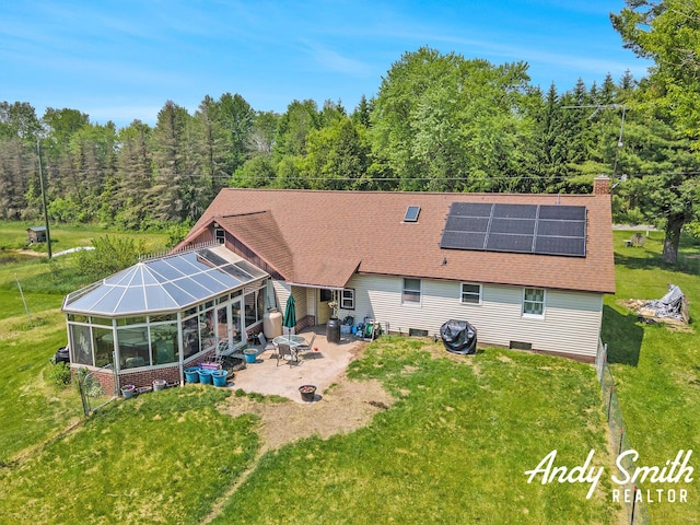 9386 N Vandecar Rd, Farwell, MI 48622 - rear view of house featuring a patio area, roof mounted solar panels, a chimney, and a yard