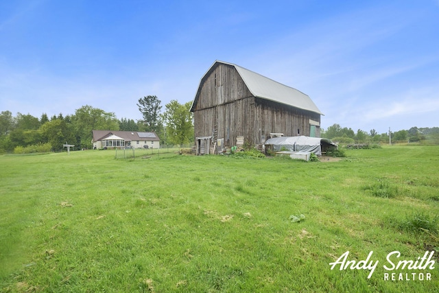 9386 N Vandecar Rd, Farwell, MI 48622 - view of green lawn with a barn and an outbuilding