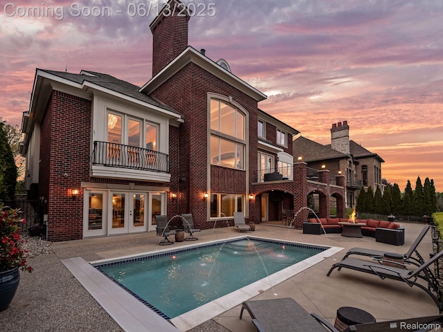 2750 Turtle Bluff Dr, Bloomfield Hills, MI 48302 - rear view of house with outdoor lounge area, a balcony, brick siding, a patio area, and french doors