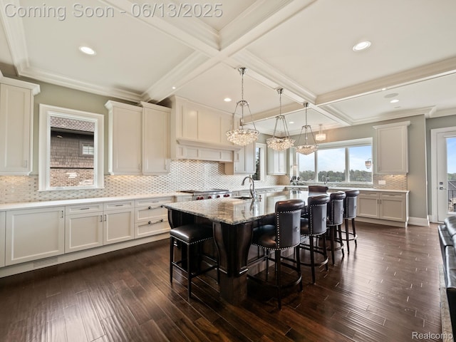 2750 Turtle Bluff Dr, Bloomfield Hills, MI 48302 - kitchen with a breakfast bar, tasteful backsplash, a kitchen island with sink, beam ceiling, and white cabinets