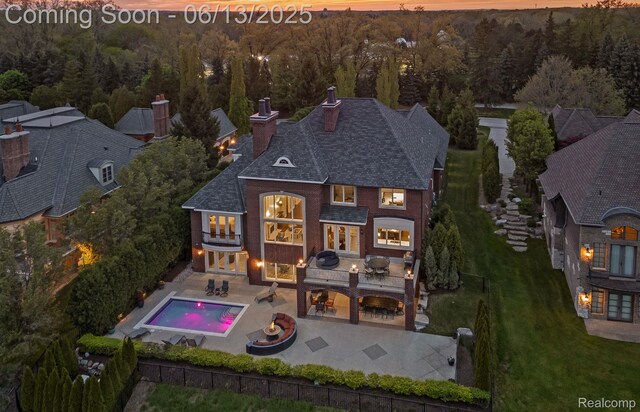 2750 Turtle Bluff Dr, Bloomfield Hills, MI 48302 - rear view of house with a forest view, a chimney, a patio area, a balcony, and a fenced backyard