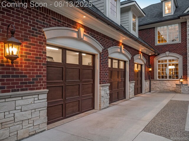 2750 Turtle Bluff Dr, Bloomfield Hills, MI 48302 - view of exterior entry with stone siding, a garage, and brick siding