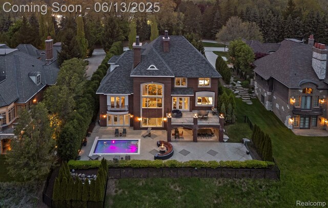 2750 Turtle Bluff Dr, Bloomfield Hills, MI 48302 - rear view of property featuring a chimney, a patio area, a balcony, roof with shingles, and a forest view