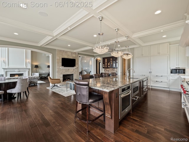 2750 Turtle Bluff Dr, Bloomfield Hills, MI 48302 - kitchen featuring a large fireplace, coffered ceiling, stainless steel appliances, beam ceiling, and a center island with sink