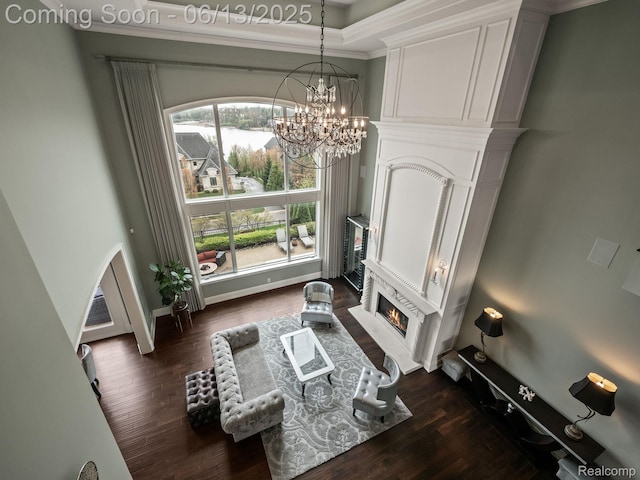 2750 Turtle Bluff Dr, Bloomfield Hills, MI 48302 - sitting room featuring dark wood-type flooring, a chandelier, a glass covered fireplace, ornamental molding, and a high ceiling