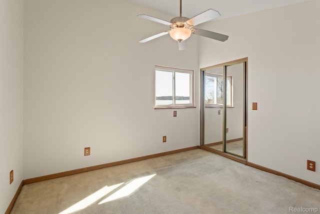 2830 N Duck Lake Rd, Highland, MI 48356 - unfurnished bedroom featuring light carpet, baseboards, a closet, and a ceiling fan