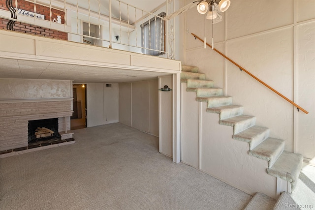 2830 N Duck Lake Rd, Highland, MI 48356 - stairway with carpet flooring, a stone fireplace, and a ceiling fan