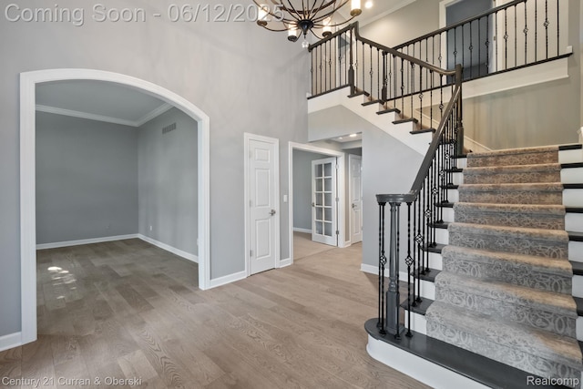 44251 Deep Hollow Cir, Northville, MI 48168 - foyer featuring crown molding, baseboards, arched walkways, a chandelier, and wood finished floors