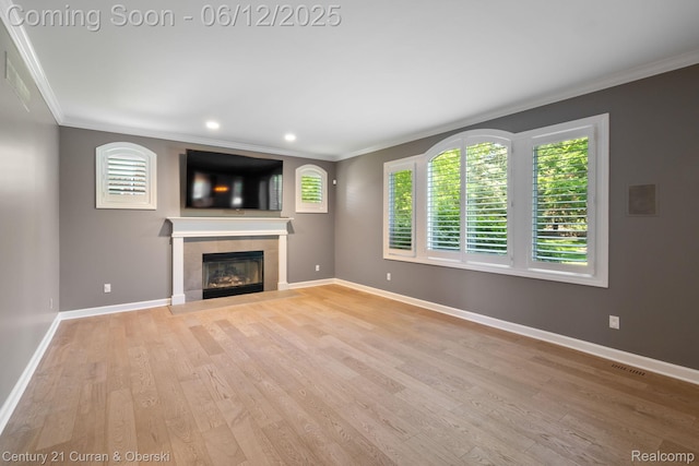 44251 Deep Hollow Cir, Northville, MI 48168 - unfurnished living room featuring ornamental molding, light wood-type flooring, a tile fireplace, baseboards, and recessed lighting
