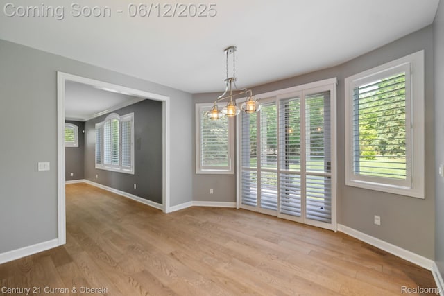 44251 Deep Hollow Cir, Northville, MI 48168 - unfurnished room featuring baseboards, wood finished floors, and a chandelier