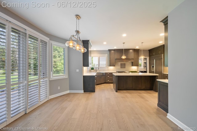 44251 Deep Hollow Cir, Northville, MI 48168 - kitchen with light countertops, paneled refrigerator, light wood-style flooring, baseboards, and a center island