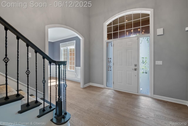 44251 Deep Hollow Cir, Northville, MI 48168 - foyer entrance featuring wood finished floors, arched walkways, baseboards, stairs, and a towering ceiling