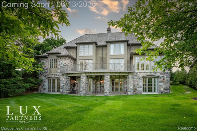 2937 Turtle Pond Ct, Bloomfield Hills, MI 48302 - back of property at dusk featuring french doors, a lawn, and stone siding