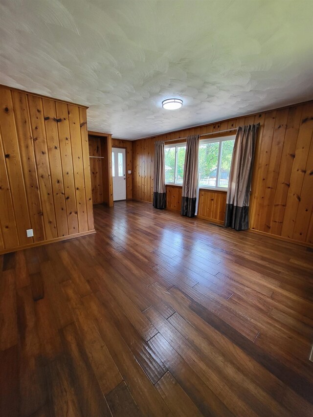 1010 S Pearce St, Owosso, MI 48867 - spare room with dark wood-style floors and wooden walls