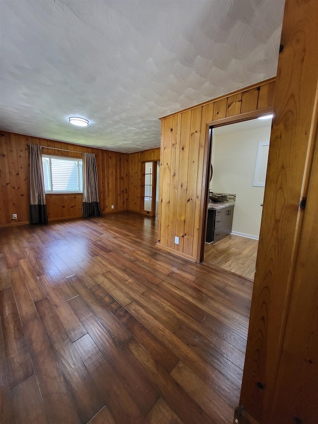 1010 S Pearce St, Owosso, MI 48867 - spare room with dark wood finished floors and wooden walls