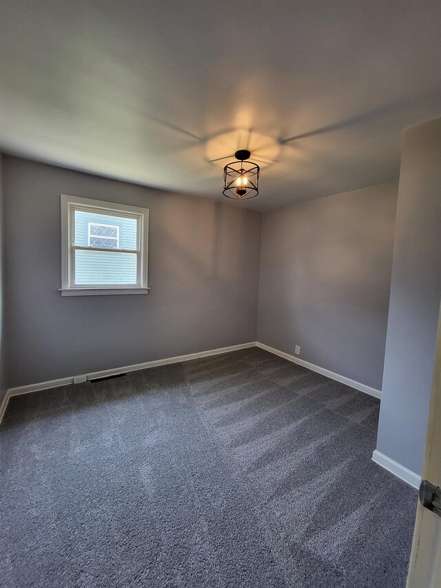 1010 S Pearce St, Owosso, MI 48867 - spare room with dark carpet and baseboards