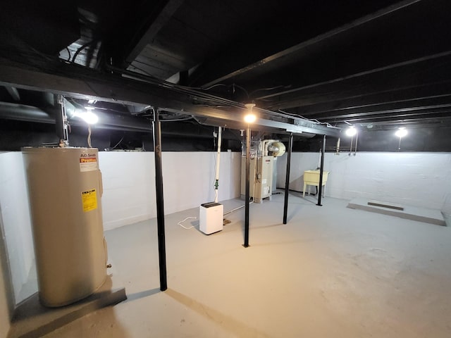 1010 S Pearce St, Owosso, MI 48867 - unfinished below grade area featuring water heater, heating unit, and a sink