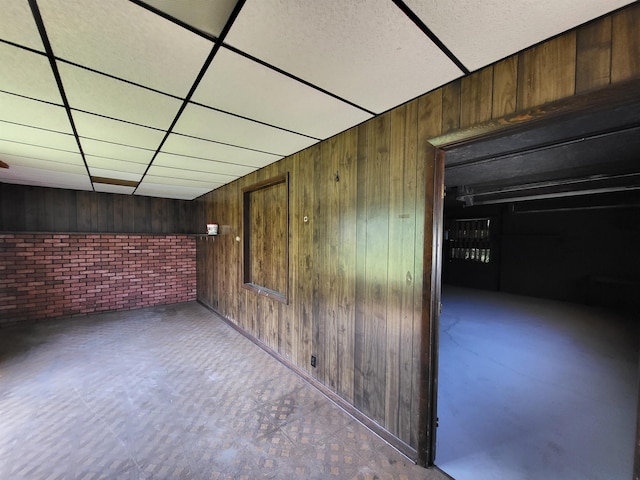 1010 S Pearce St, Owosso, MI 48867 - hallway with brick wall, wood walls, and a drop ceiling