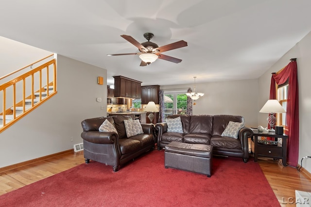 1377 Maplewood Dr St, Saline, MI 48176 - living area featuring stairs, a ceiling fan, wood finished floors, and baseboards