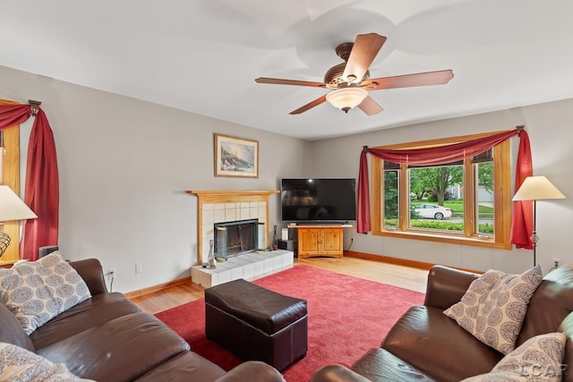 1377 Maplewood Dr St, Saline, MI 48176 - living area with light wood-type flooring, ceiling fan, a tile fireplace, and baseboards