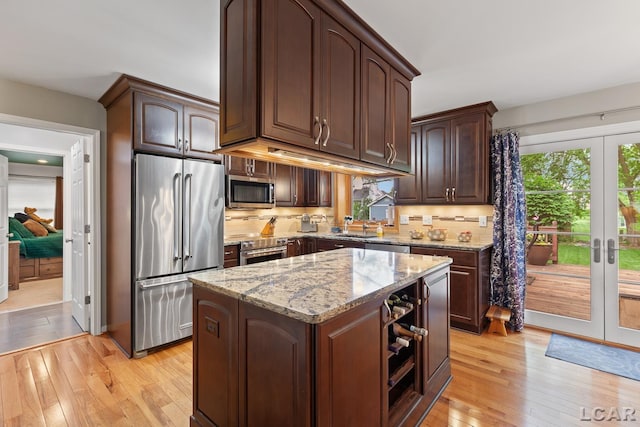 1377 Maplewood Dr St, Saline, MI 48176 - kitchen featuring appliances with stainless steel finishes, light wood-style floors, light stone counters, french doors, and backsplash
