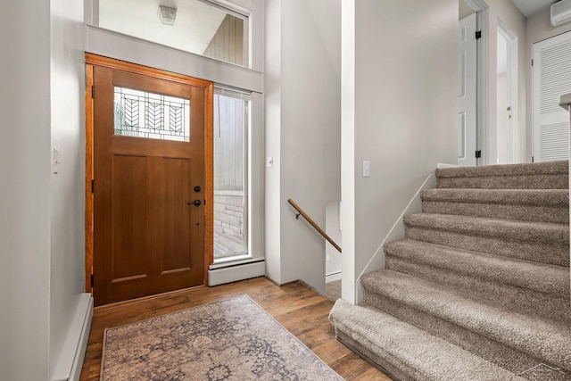 1449 Sauk Ln, Saginaw, MI 48638 - foyer with a baseboard heating unit, wood finished floors, a wall mounted air conditioner, and stairway