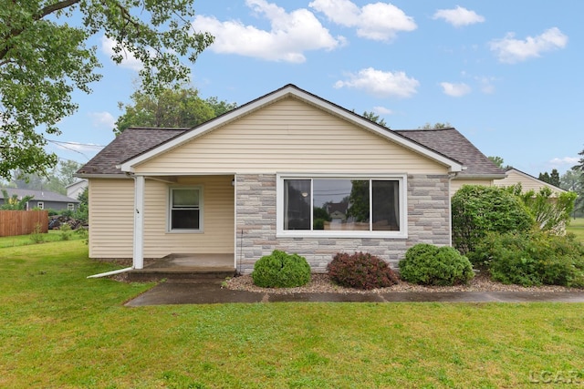 1104 Sunset Dr, Tecumseh, MI 49286 - view of front facade with stone siding, roof with shingles, a front lawn, and a porch