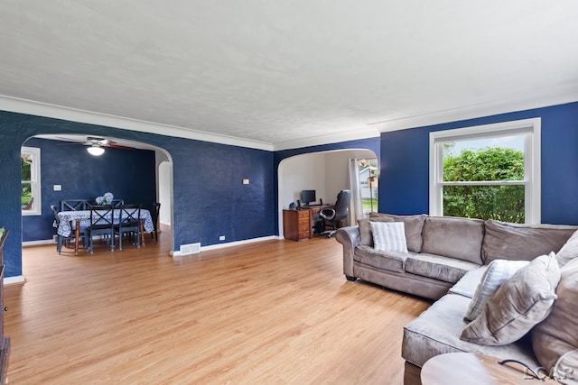 1104 Sunset Dr, Tecumseh, MI 49286 - living room with arched walkways, a ceiling fan, light wood finished floors, baseboards, and ornamental molding