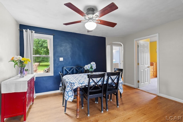 1104 Sunset Dr, Tecumseh, MI 49286 - dining room featuring arched walkways, light wood-type flooring, and baseboards