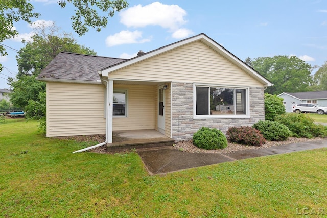 1104 Sunset Dr, Tecumseh, MI 49286 - view of front of home featuring a front lawn, stone siding, a shingled roof, and covered porch