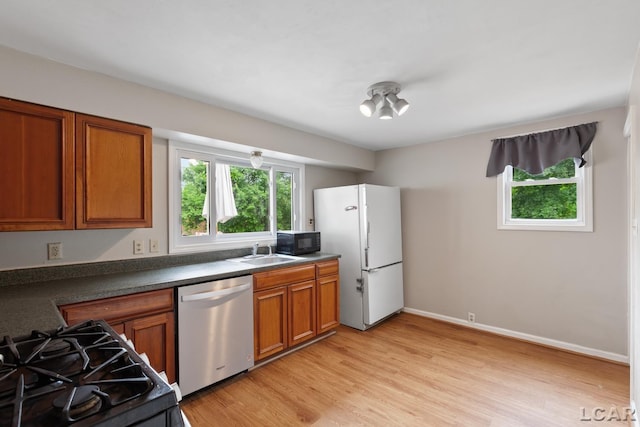 1104 Sunset Dr, Tecumseh, MI 49286 - kitchen featuring stainless steel dishwasher, freestanding refrigerator, healthy amount of natural light, and a sink