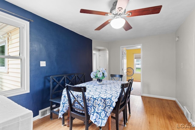 1104 Sunset Dr, Tecumseh, MI 49286 - dining area with baseboards, light wood finished floors, arched walkways, and a ceiling fan