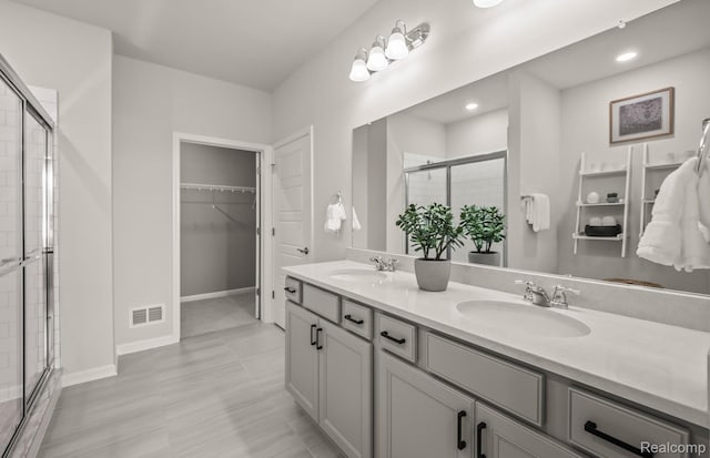 3013 Sheffield Cir, Clarkston, MI 48346 - bathroom featuring a shower stall, double vanity, a walk in closet, and recessed lighting