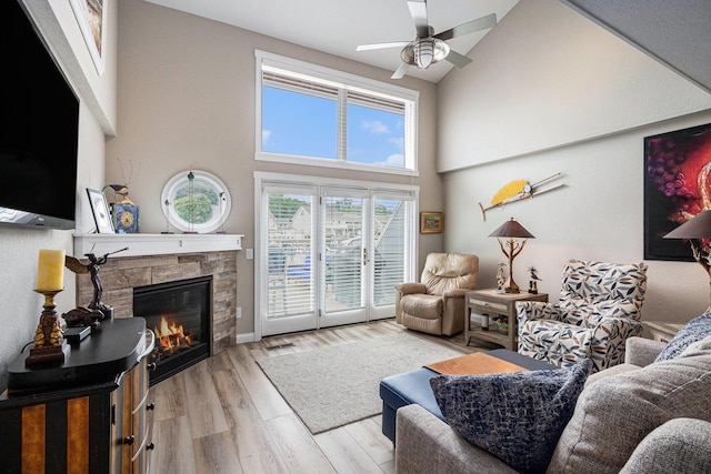 144 Dunkley Ave Unit 4, South Haven, MI 49090 - living room with a stone fireplace, ceiling fan, wood finished floors, and a towering ceiling