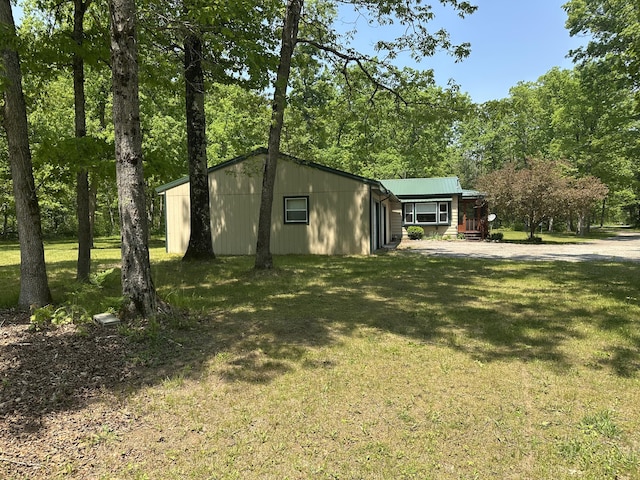 5649 W 76th St, Baldwin, MI 49304 - view of side of home with a lawn