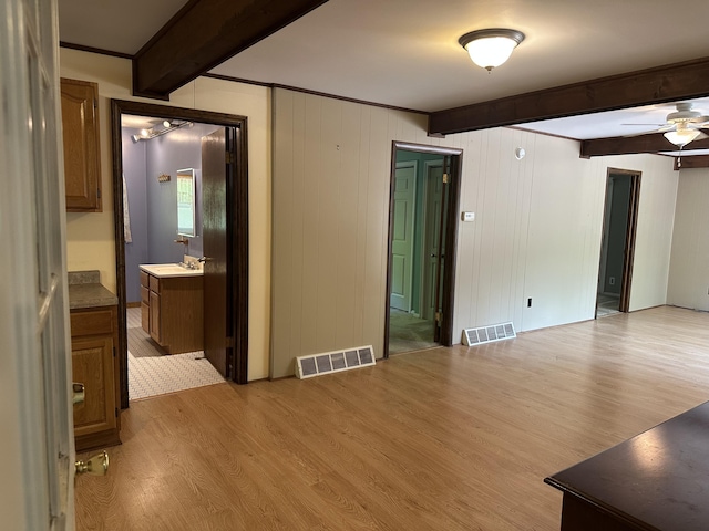 5649 W 76th St, Baldwin, MI 49304 - spare room with beam ceiling, light wood-style flooring, a ceiling fan, and a sink