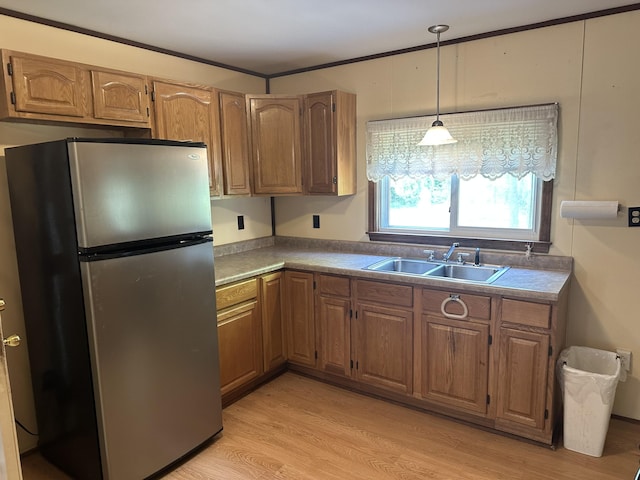 5649 W 76th St, Baldwin, MI 49304 - kitchen with freestanding refrigerator, a sink, light wood-type flooring, brown cabinetry, and crown molding