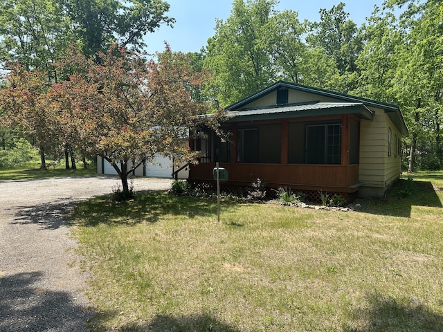 5649 W 76th St, Baldwin, MI 49304 - view of front of house with a front yard, driveway, and a garage