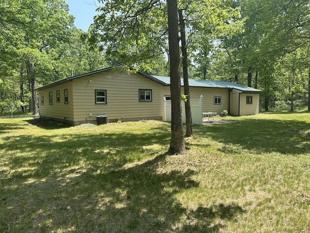 5649 W 76th St, Baldwin, MI 49304 - view of home's exterior with central AC unit, a lawn, and view of scattered trees