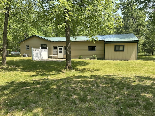 5649 W 76th St, Baldwin, MI 49304 - rear view of house with a yard, central AC unit, and metal roof
