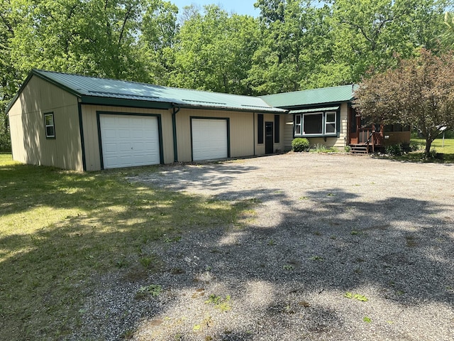 5649 W 76th St, Baldwin, MI 49304 - ranch-style home with a garage, metal roof, and gravel driveway