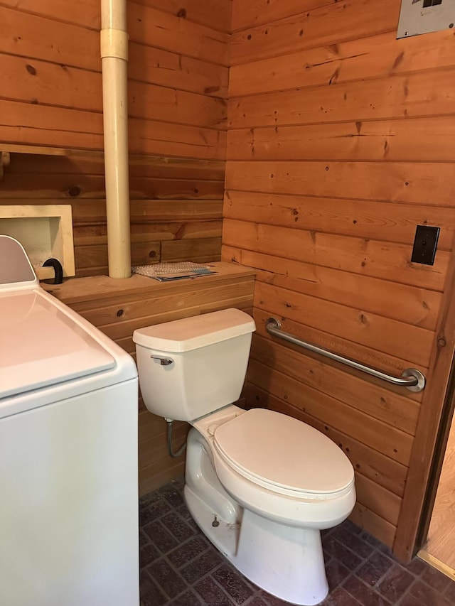 5649 W 76th St, Baldwin, MI 49304 - half bath with washer / clothes dryer, wood walls, toilet, and brick patterned floors